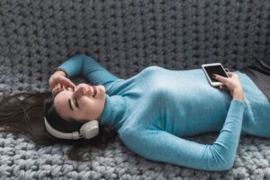 Jeune femme écoutant de la musique avec un casque nomade bluetooth