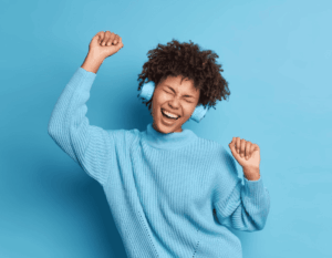 Jeune femme heureuse qui danse pendant qu'elle écoute de la musique