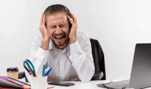 Homme au travail qui n'en peut plus et se bouche les oreilles