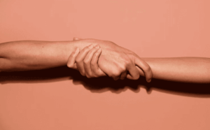 2 bras reliés entre eux par des mains qui se tiennent, symbole de l'entraide