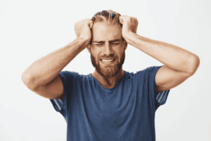 Homme stressé qui se tient la tête à deux mains