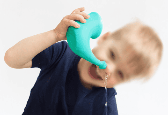 Garçon qui se lave le nez avec poire à lavement