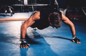 Jeune homme faisant des pompes en salle d'entrainement