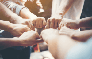 Réunion de plusieurs bras adultes au travail pour symboliser la force de la collaboration