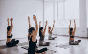 Femmes les bras en l'air pendant une séance de yoga