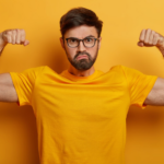 Homme montrant ses muscles, illustrant la puissance nécessaire pour adapter une aide auditive au niveau de perte auditive.