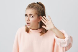 Femme qui tend l'oreille à cause d'une perte auditive soudaine.