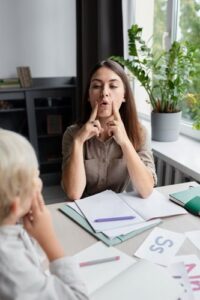 Femme indiquant un son à un enfant pour la compréhension