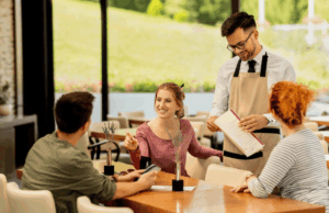 Femme échangeant avec des proches dans un restaurant, illustrant les besoins auditifs liés à une vie sociale active et aux environnements bruyants.