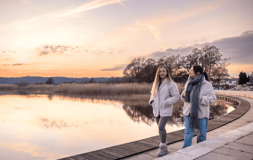 Deux femmes marchant tranquillement dans un paysage naturel paisible, illustrant le bien-être et la capacité à vivre sereinement malgré les acouphènes.