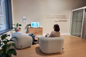 Salle d’accueil Acoustico avec deux patients assis, illustrant un accompagnement personnalisé et un environnement chaleureux dédié aux solutions auditives.