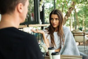 Jeune femme qui entend moins et fait un signe d'incompréhension