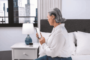 Personne utilisant un smartphone connecté à un appareil auditif Phonak