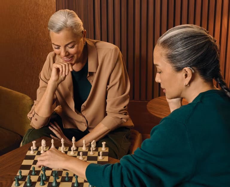 Femme portant un appareil auditif jouant aux échecs