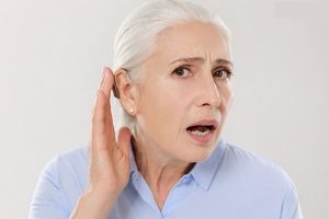 Dame qui a des problème pour entendre avec son appareil auditif